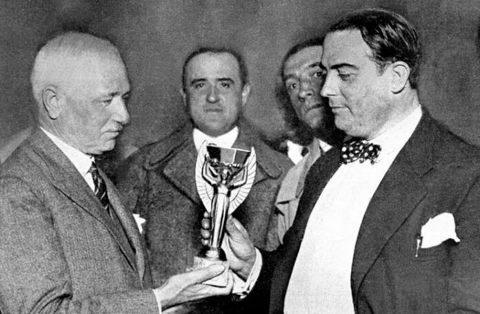 Jules Rimet menyerahkan trofi untuk diperebutkan pada Piala Dunia 1930 di Uruguay.