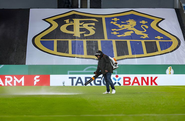 Petugas coba mengusir air dari lapangan di Stadion Ludwigspark.