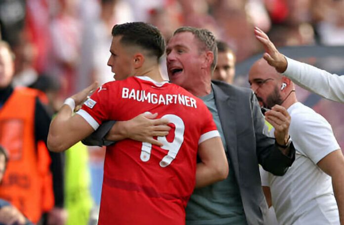 Ralf Rangnick mengamankan kacamatanya saat memeluk Christoph Baumgartner.